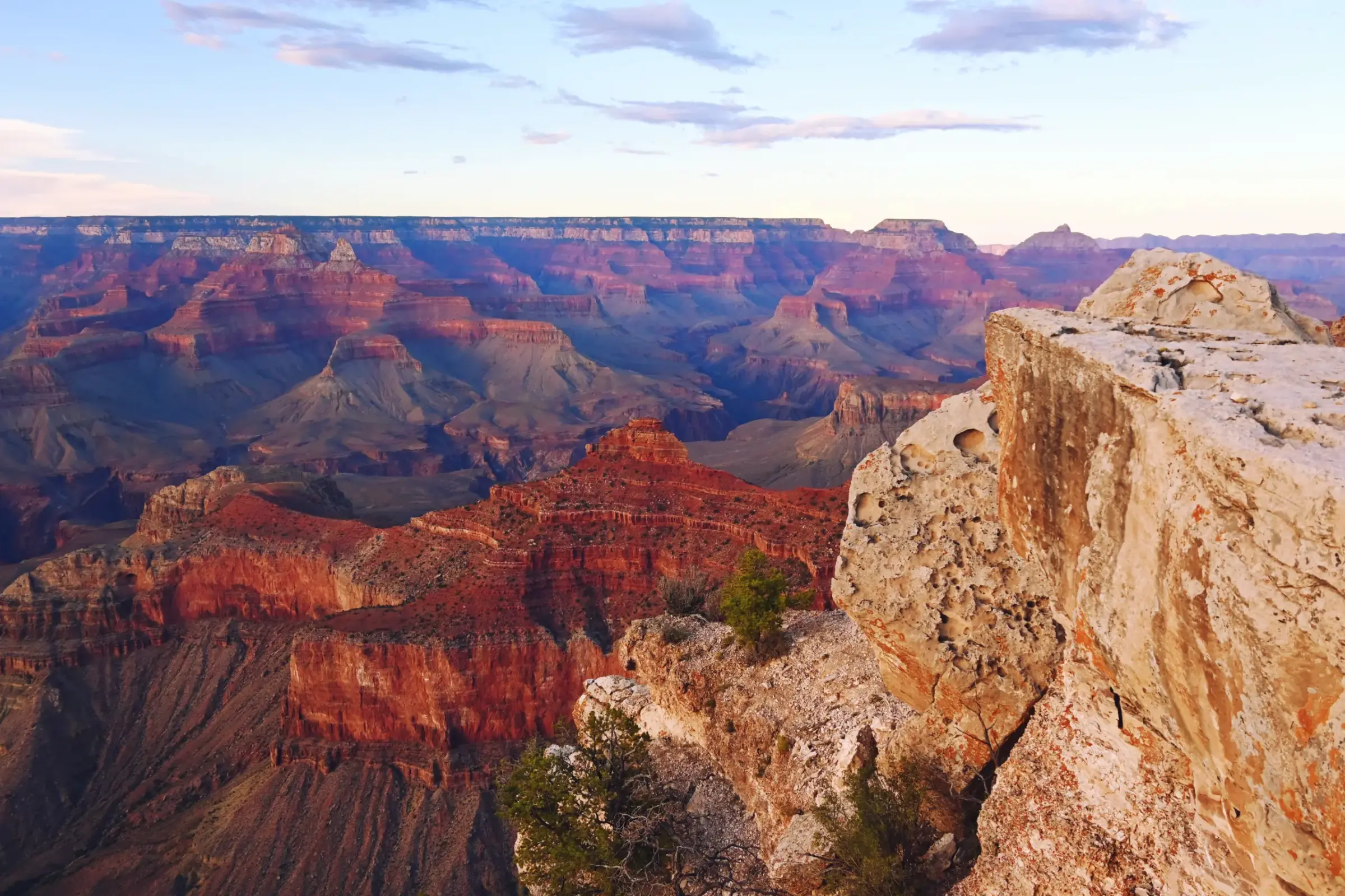 Layers of red rock stretching across the Grand Canyon at golden hour.