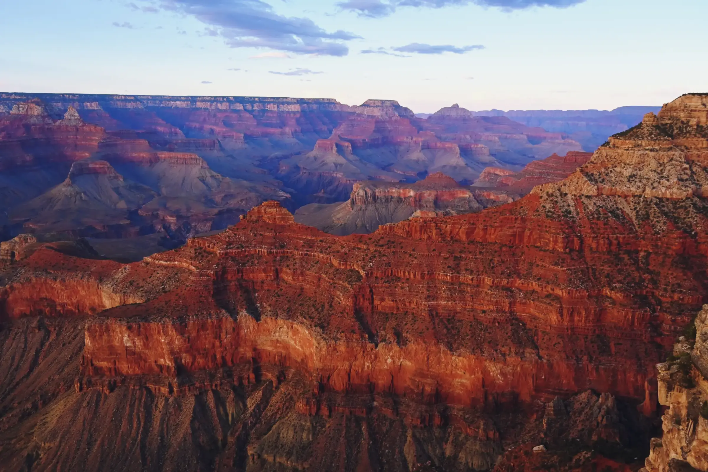 Layers of red rock stretching across the Grand Canyon at golden hour.
